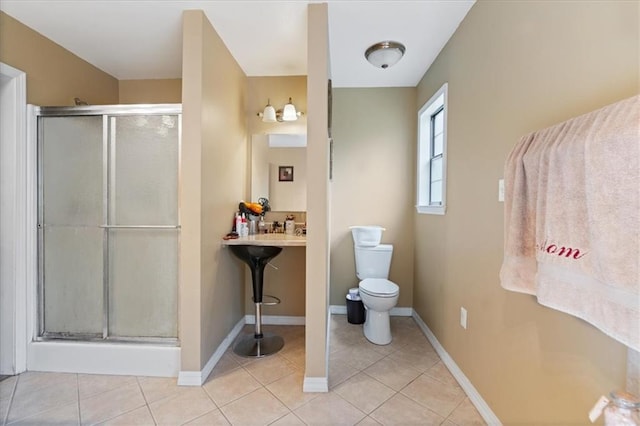 bathroom with walk in shower, toilet, and tile patterned floors