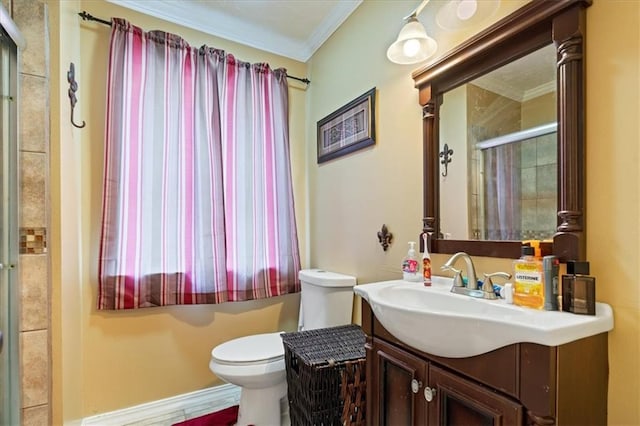 bathroom featuring a shower with shower door, vanity, toilet, and ornamental molding