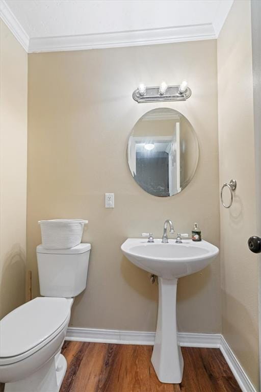 bathroom featuring toilet, wood-type flooring, sink, and crown molding