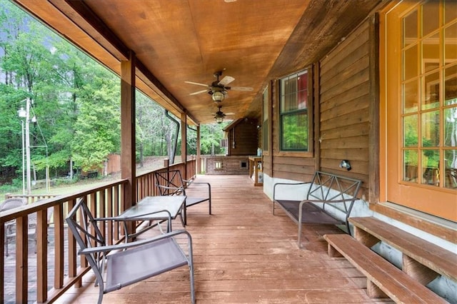 wooden deck featuring covered porch and ceiling fan