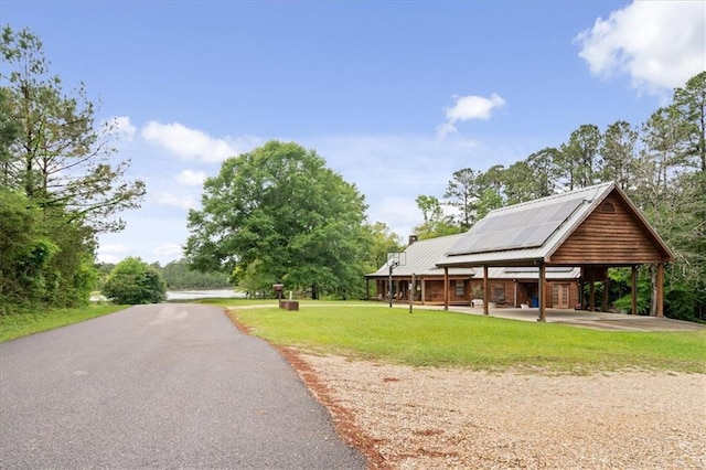 surrounding community with a lawn and a carport