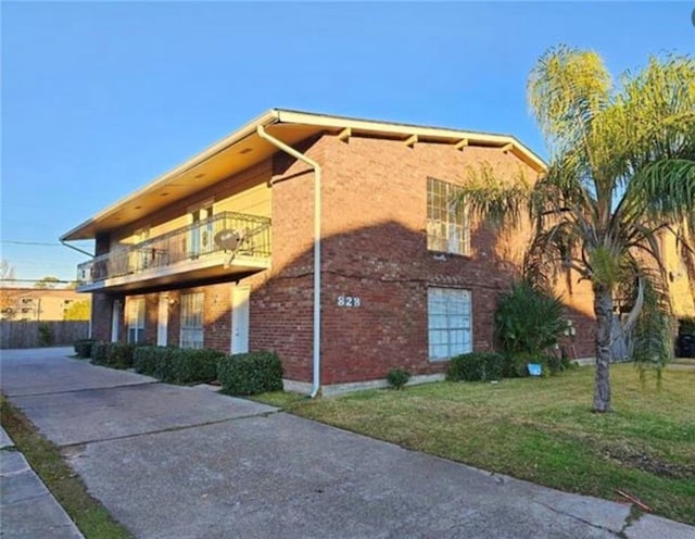 view of property exterior featuring a yard and a balcony