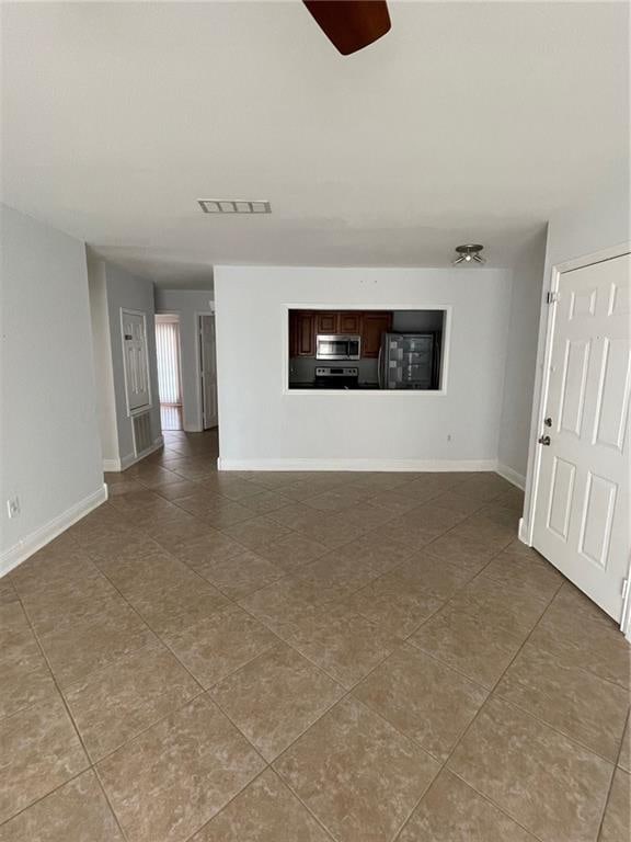 unfurnished living room with ceiling fan and tile patterned flooring