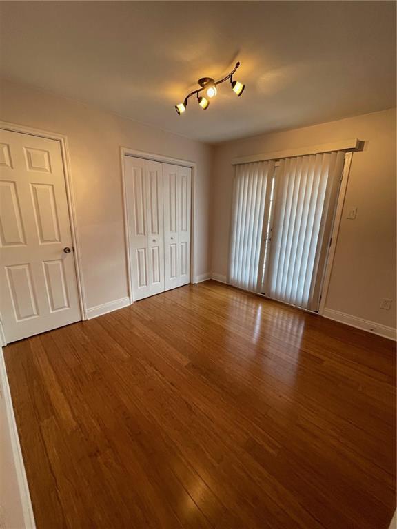 unfurnished bedroom with hardwood / wood-style flooring