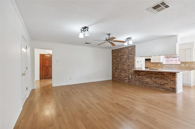 unfurnished living room with crown molding, light wood-type flooring, and ceiling fan