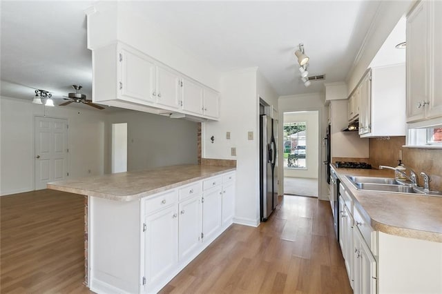 kitchen with white cabinetry, sink, kitchen peninsula, and stainless steel refrigerator with ice dispenser