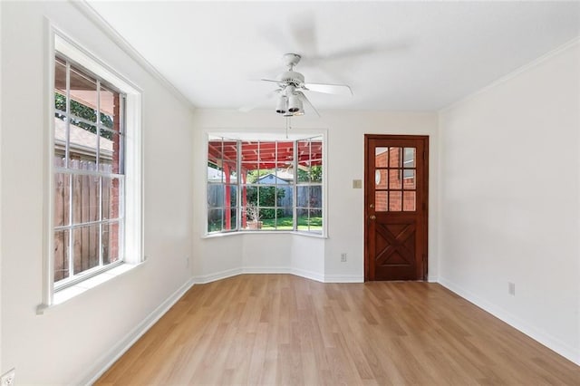 entryway featuring light wood-type flooring, crown molding, and plenty of natural light