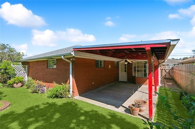 back of property featuring a patio area and a lawn