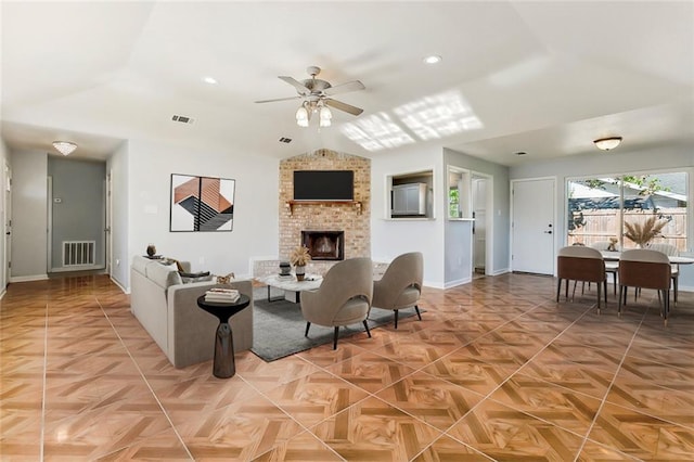 living area featuring lofted ceiling, a fireplace, visible vents, and a ceiling fan