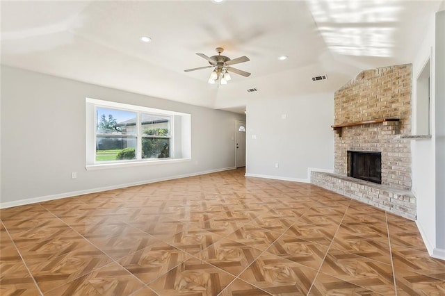 unfurnished living room featuring a brick fireplace, ceiling fan, visible vents, and baseboards