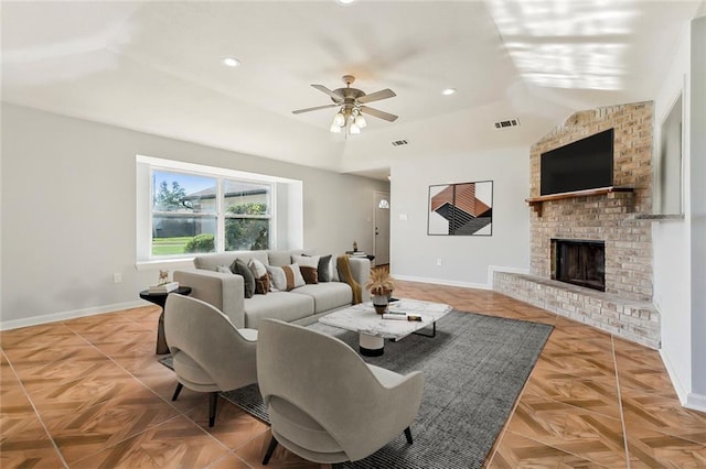 living area with ceiling fan, a fireplace, visible vents, and baseboards