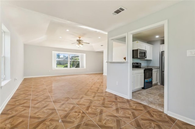 kitchen featuring light stone countertops, electric range, white cabinets, and ceiling fan