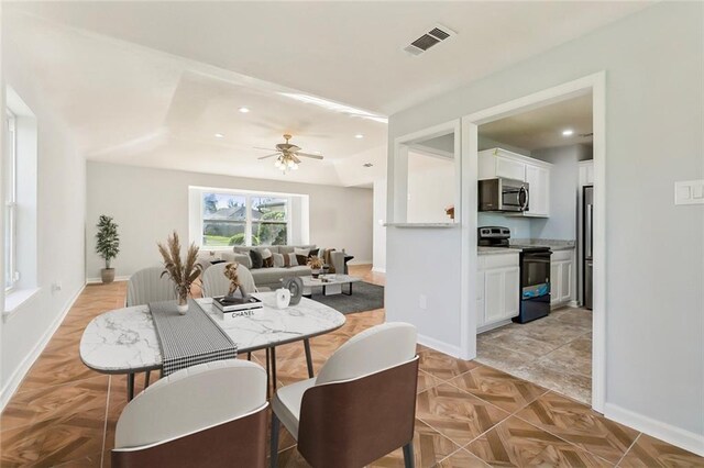 kitchen featuring stainless steel appliances, sink, light stone countertops, light tile patterned floors, and white cabinets