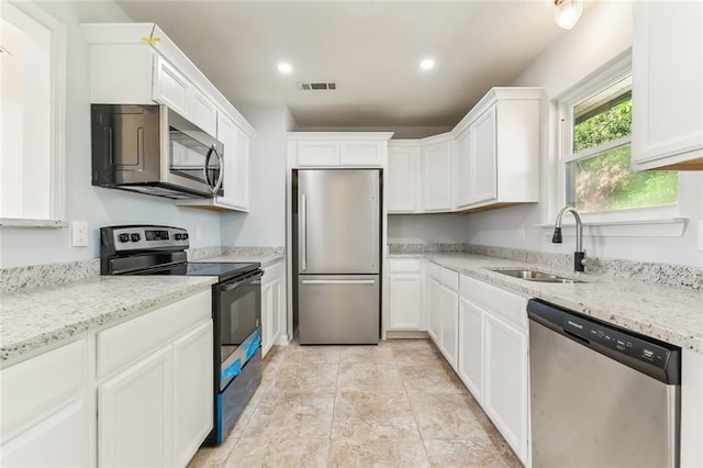 kitchen featuring visible vents, stainless steel appliances, a sink, and white cabinetry