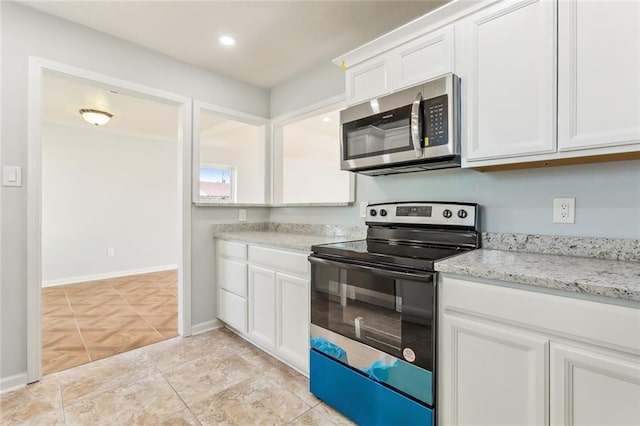 kitchen featuring range with electric cooktop, white cabinetry, baseboards, light stone countertops, and stainless steel microwave