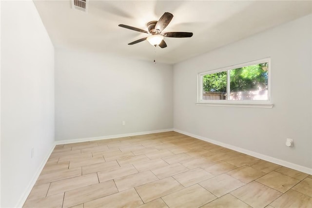 spare room with ceiling fan, visible vents, and baseboards