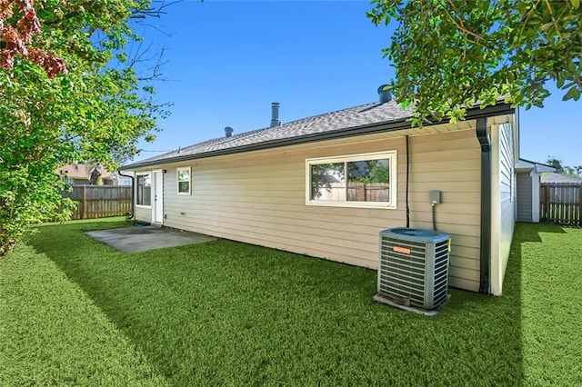 rear view of property with a patio, central air condition unit, and a lawn