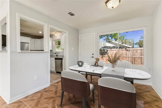 dining space featuring plenty of natural light, visible vents, and baseboards