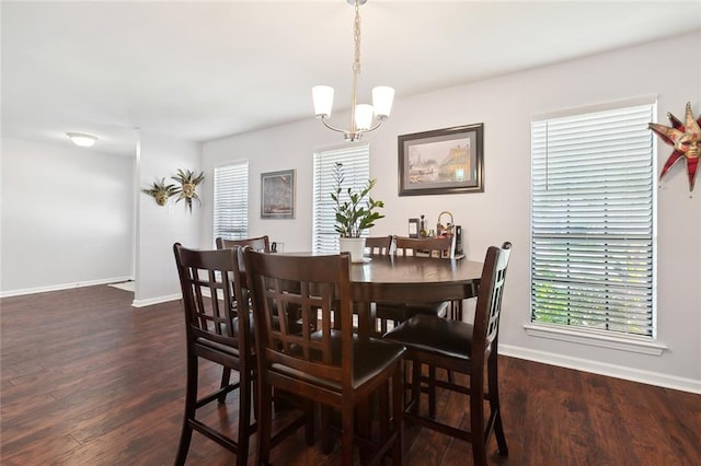 dining space with a notable chandelier and dark hardwood / wood-style flooring