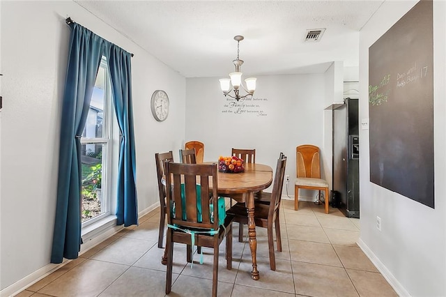 tiled dining room with an inviting chandelier