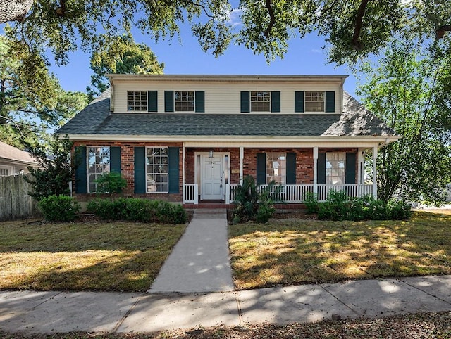 view of front of house featuring covered porch and a front lawn