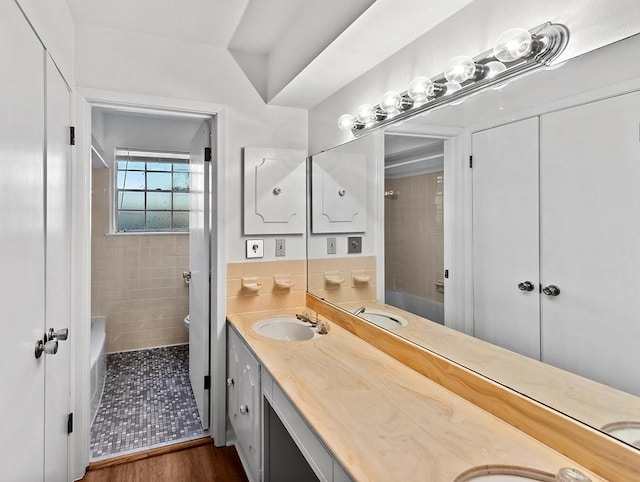 bathroom with vanity, tiled shower, and hardwood / wood-style floors