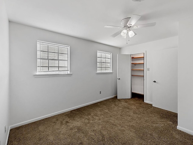 unfurnished bedroom with ceiling fan and dark carpet