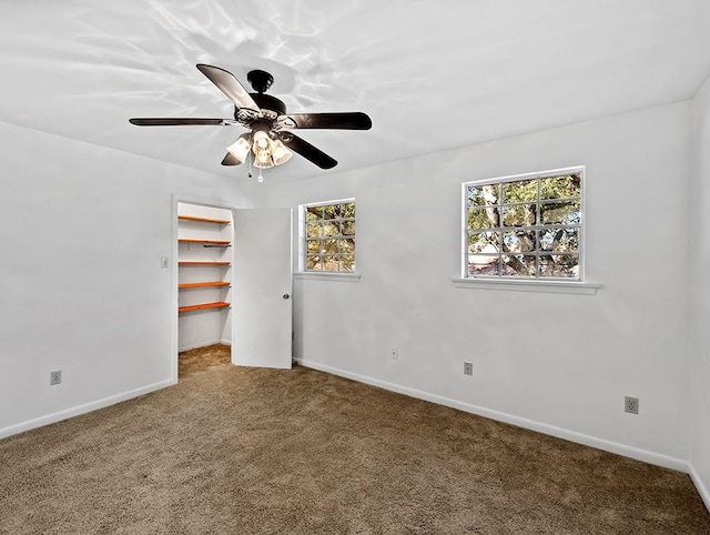 unfurnished bedroom featuring a spacious closet, ceiling fan, a closet, and carpet