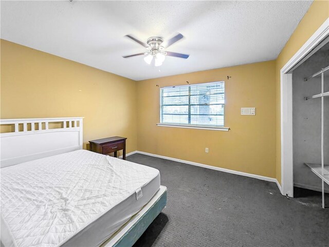 bedroom with ceiling fan, a textured ceiling, a closet, and dark colored carpet