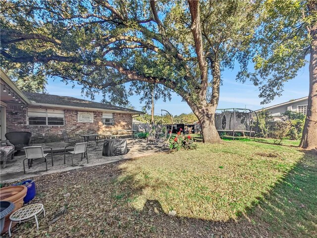 view of yard featuring a trampoline and a patio area