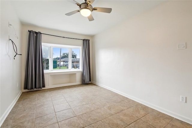 tiled spare room featuring ceiling fan