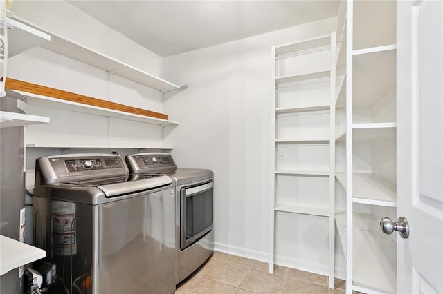 washroom featuring washing machine and clothes dryer and light tile patterned floors