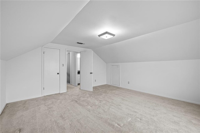 bonus room with visible vents, vaulted ceiling, and light colored carpet