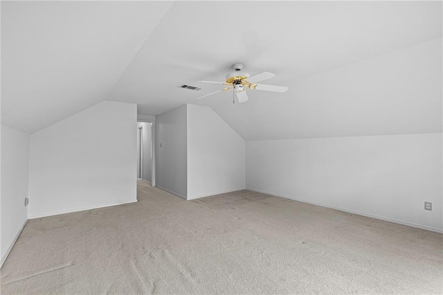 additional living space featuring lofted ceiling, light colored carpet, visible vents, a ceiling fan, and baseboards