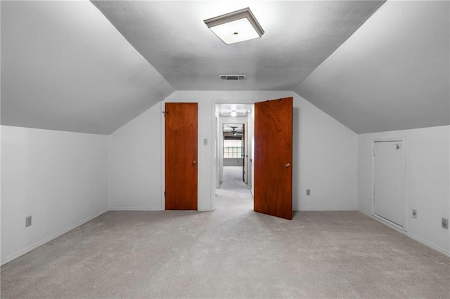 additional living space featuring lofted ceiling and light colored carpet