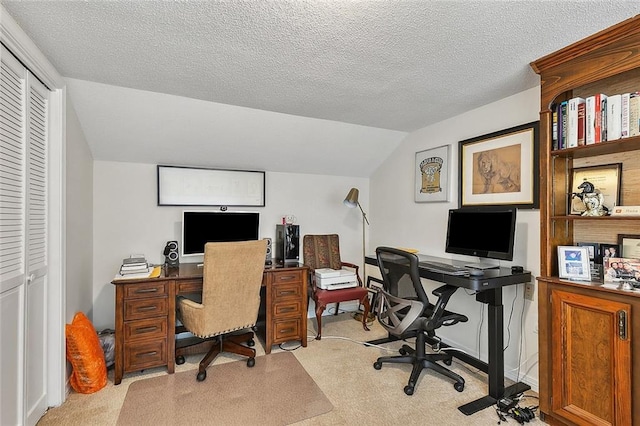 carpeted home office featuring lofted ceiling and a textured ceiling