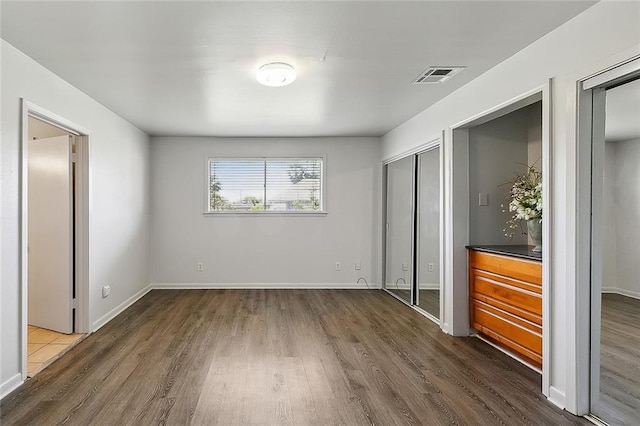 unfurnished bedroom featuring dark hardwood / wood-style flooring