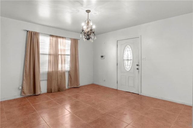 tiled entryway featuring a chandelier and a healthy amount of sunlight