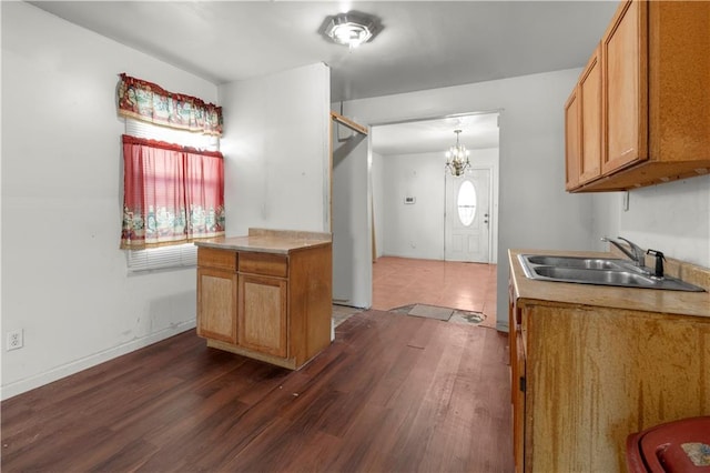 kitchen featuring an inviting chandelier, dark hardwood / wood-style floors, sink, and pendant lighting