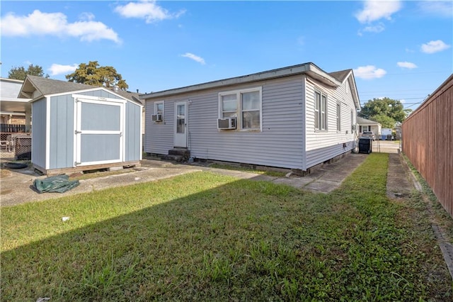 rear view of house featuring a storage shed and a yard