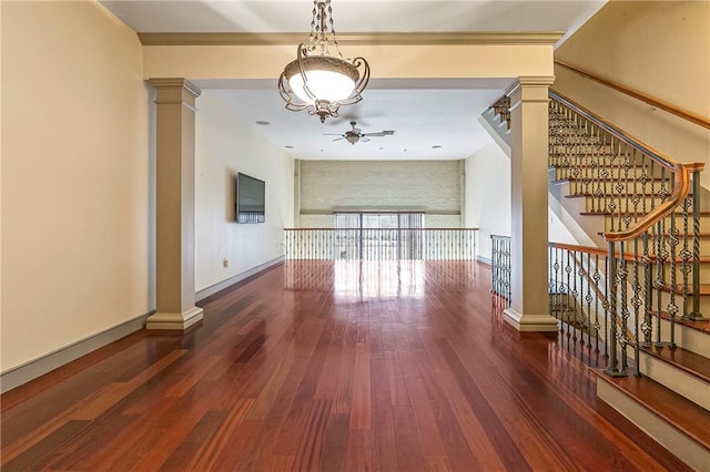 unfurnished living room with ornate columns, dark hardwood / wood-style flooring, and ceiling fan