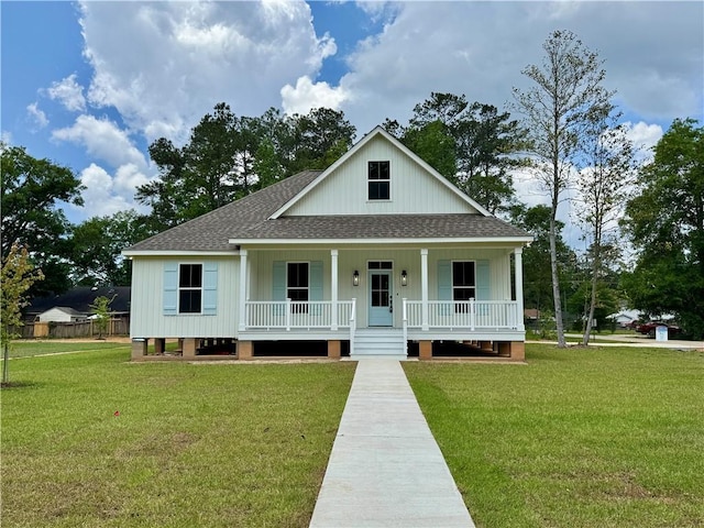 view of front of house featuring covered porch, a shingled roof, and a front yard
