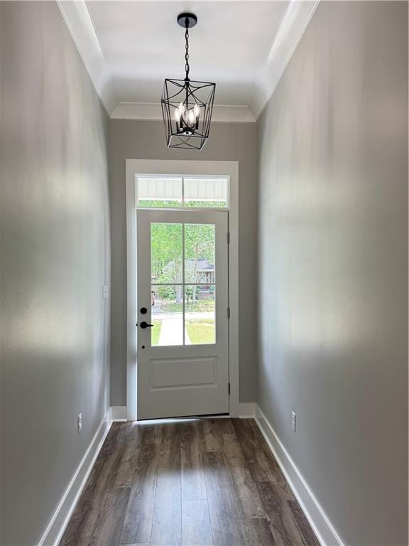 doorway to outside featuring baseboards, ornamental molding, a notable chandelier, and dark wood-type flooring