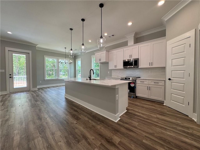 kitchen with crown molding, white cabinets, appliances with stainless steel finishes, and dark wood finished floors