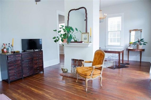 living area featuring dark wood-type flooring and an inviting chandelier