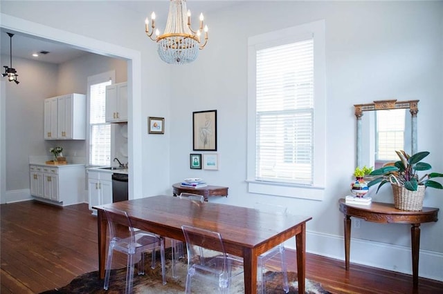 dining area with a notable chandelier, plenty of natural light, and dark hardwood / wood-style flooring