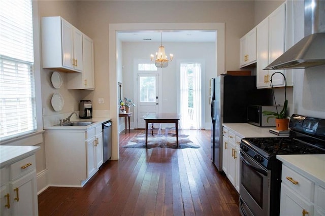 kitchen with wall chimney range hood, stainless steel appliances, sink, white cabinetry, and dark hardwood / wood-style flooring