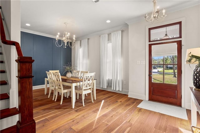 dining area featuring crown molding, hardwood / wood-style flooring, and an inviting chandelier