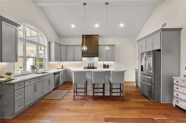 kitchen with a breakfast bar, a center island, light hardwood / wood-style flooring, and stainless steel appliances