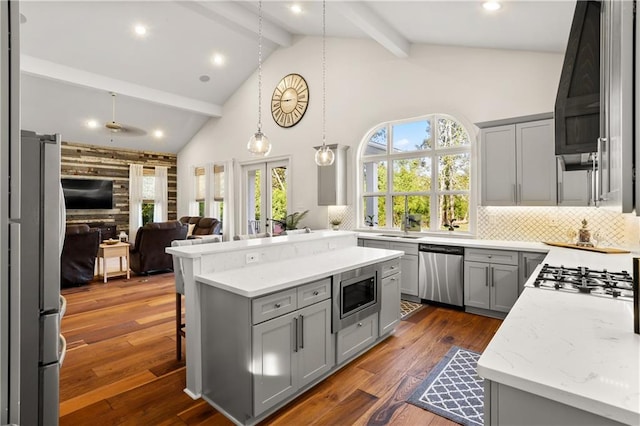 kitchen featuring appliances with stainless steel finishes, backsplash, pendant lighting, gray cabinets, and dark hardwood / wood-style floors